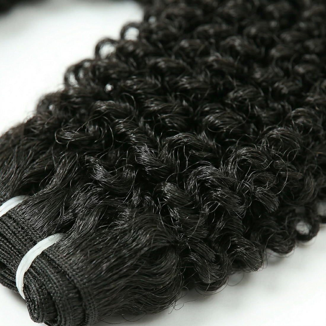 Black curly hair extensions on a white background